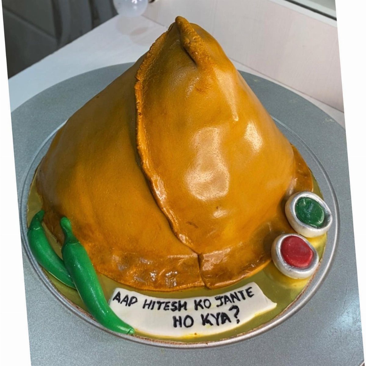 24 Funny Cakes Ideas for Birthdays, From Pizza to Poop Emoji 16 Samosa shaped cake with green and red chutney and chili peppers on platter