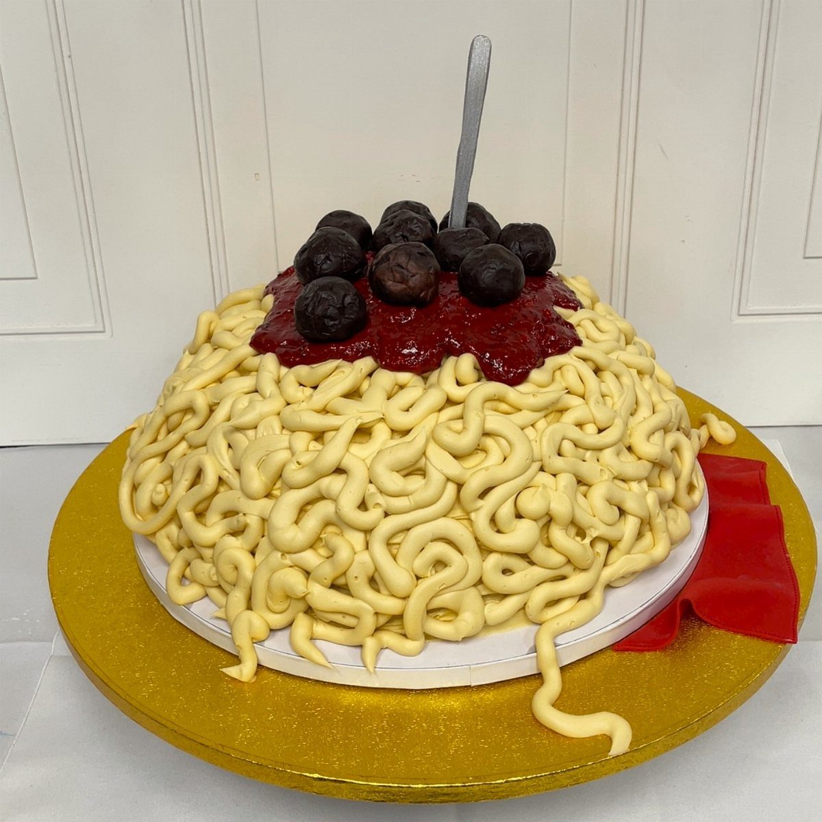 24 Funny Cakes Ideas for Birthdays, From Pizza to Poop Emoji 4 Spaghetti and meatballs cake with yellow frosting noodles and chocolate meatballs on gold platter