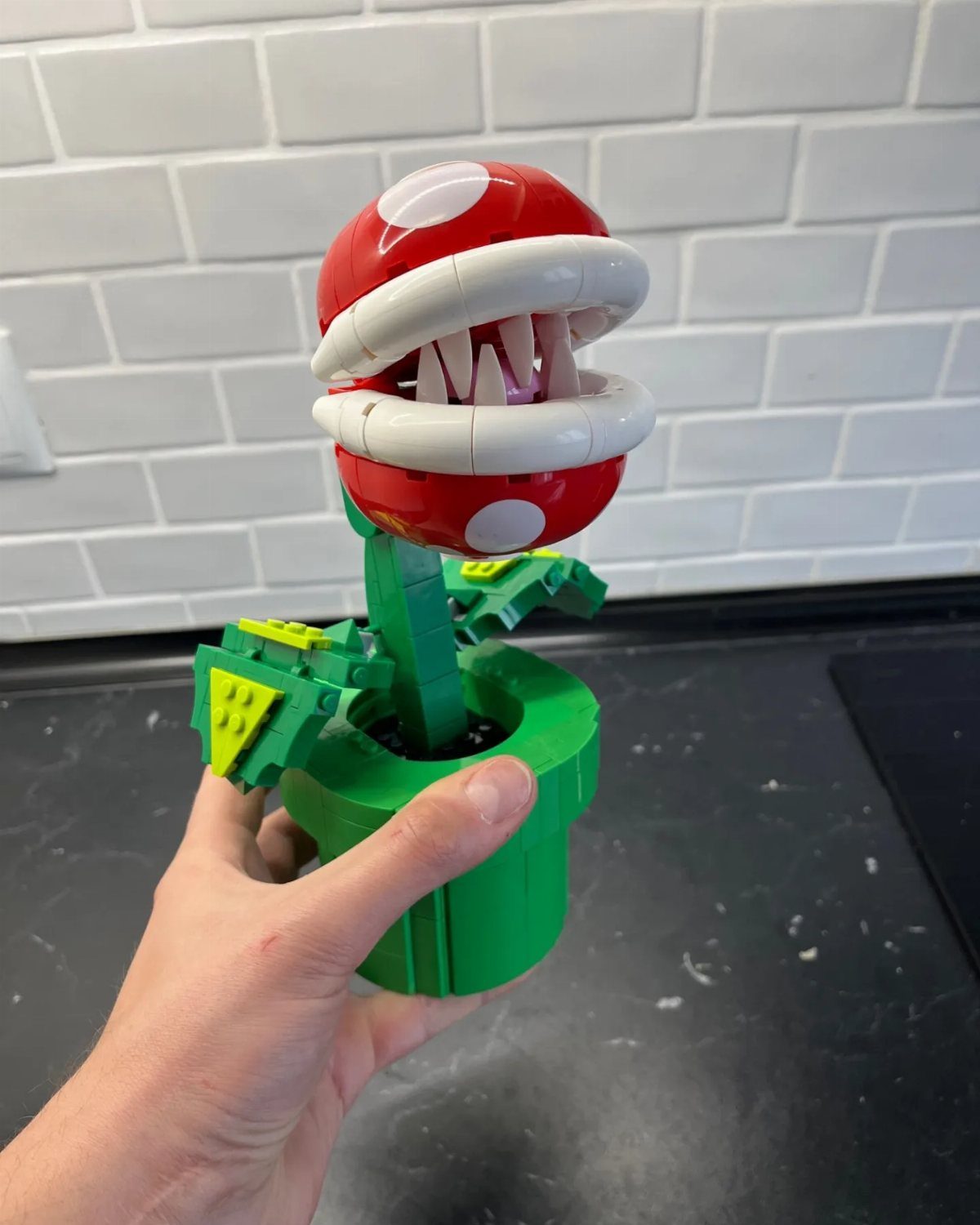 38 Gift Ideas for 13th Birthday in 2026, From Snoopy to LEGO 8 LEGO Piranha Plant with red spotted head and green pot held by a hand.