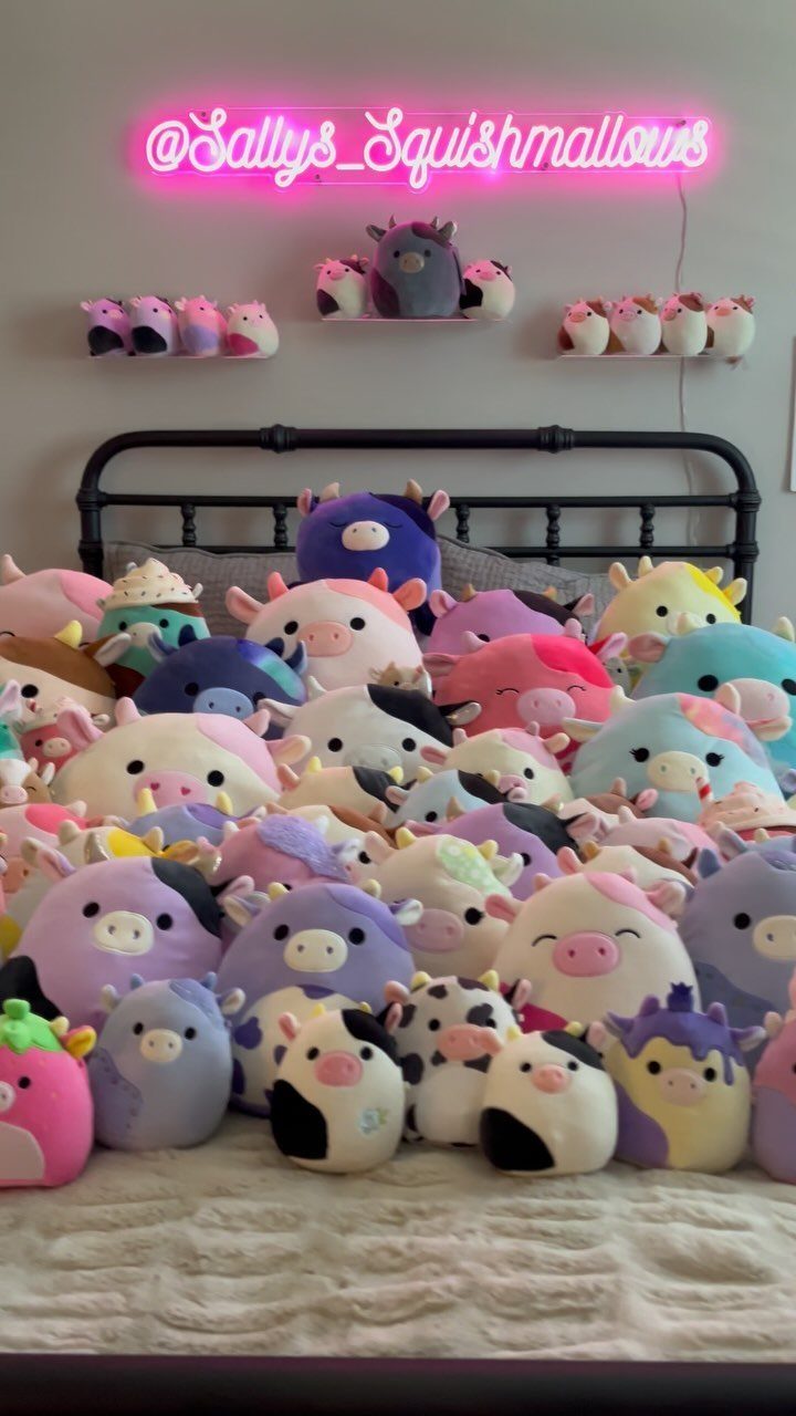 38 Gift Ideas for 13th Birthday in 2026, From Snoopy to LEGO 19 Many colorful cow-themed Squishmallows plush toys piled on a bed under a pink neon sign.