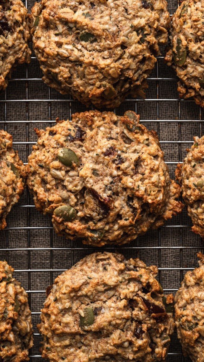 Oatmeal cookies with seeds and dried fruit on a metal wire cooling rack
