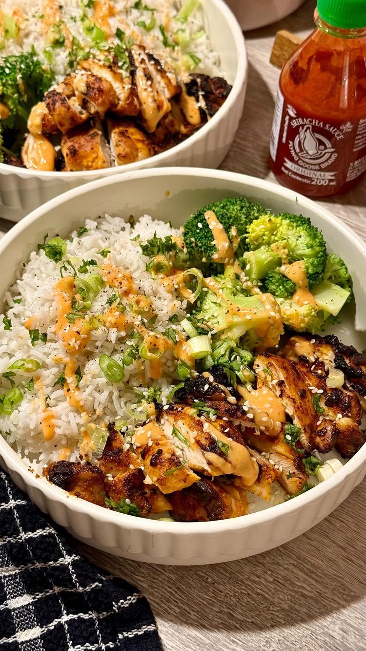 Grilled chicken and steamed broccoli served over white rice in white bowls.