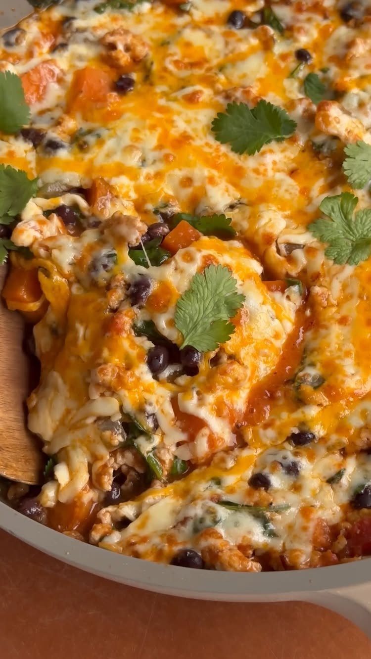 Cheesy turkey and vegetable skillet with black beans and fresh cilantro garnish.