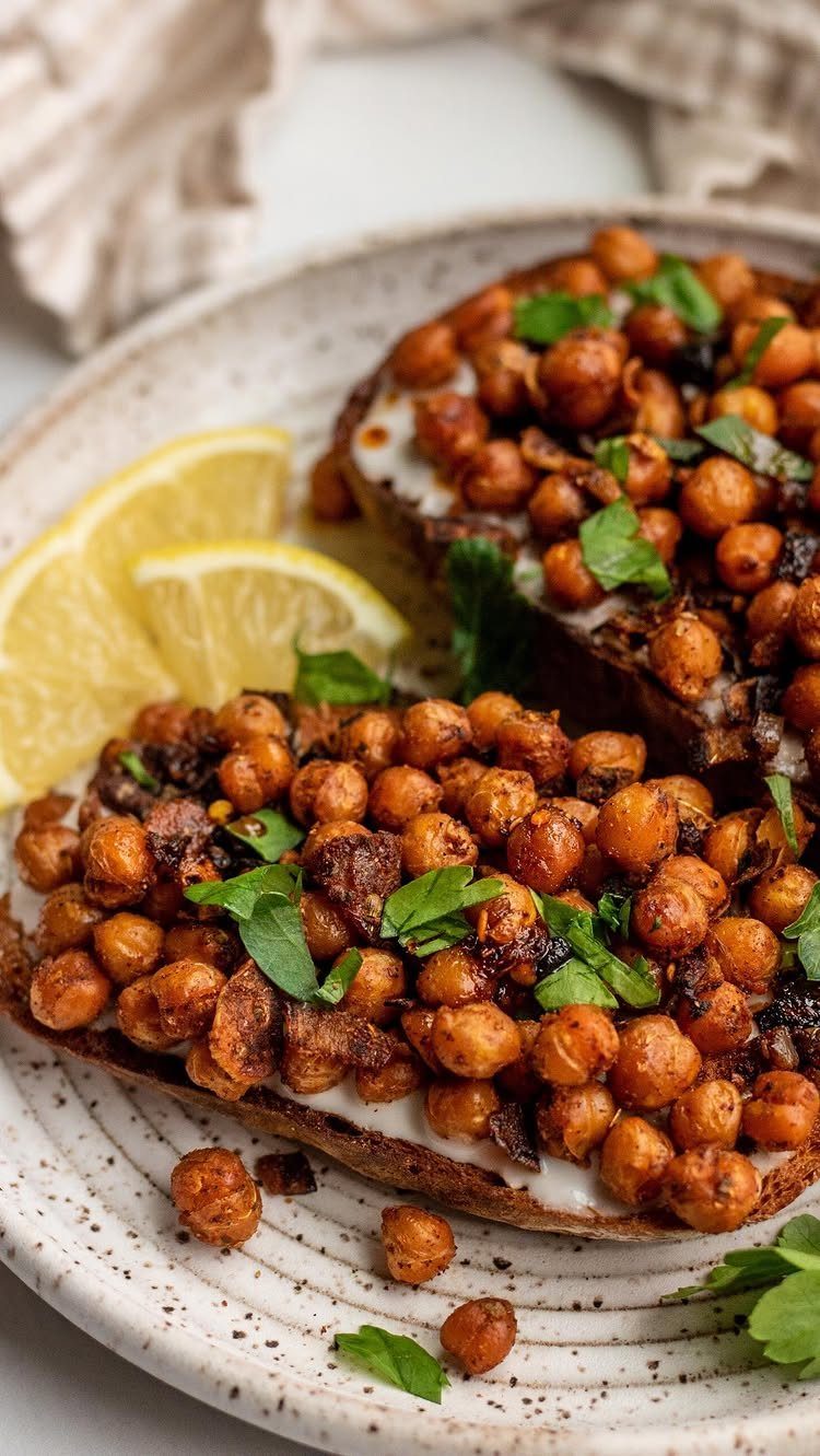 21 Healthy Mini Snacks for Lunchboxes, Parties and Busy Days 15 Roasted chickpeas on toasted bread with creamy spread and lemon wedges on a plate.