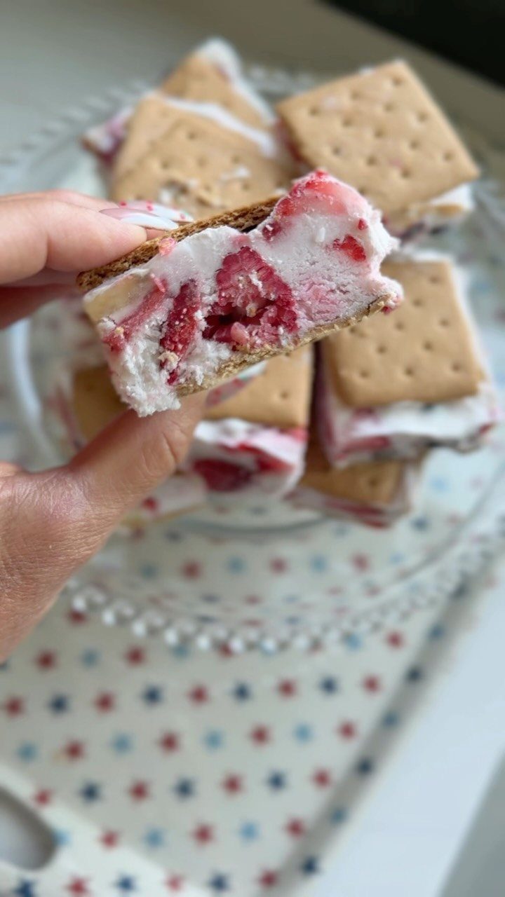 21 Healthy Mini Snacks for Lunchboxes, Parties and Busy Days 3 Frozen yogurt sandwich with berries between graham crackers held over a glass plate.