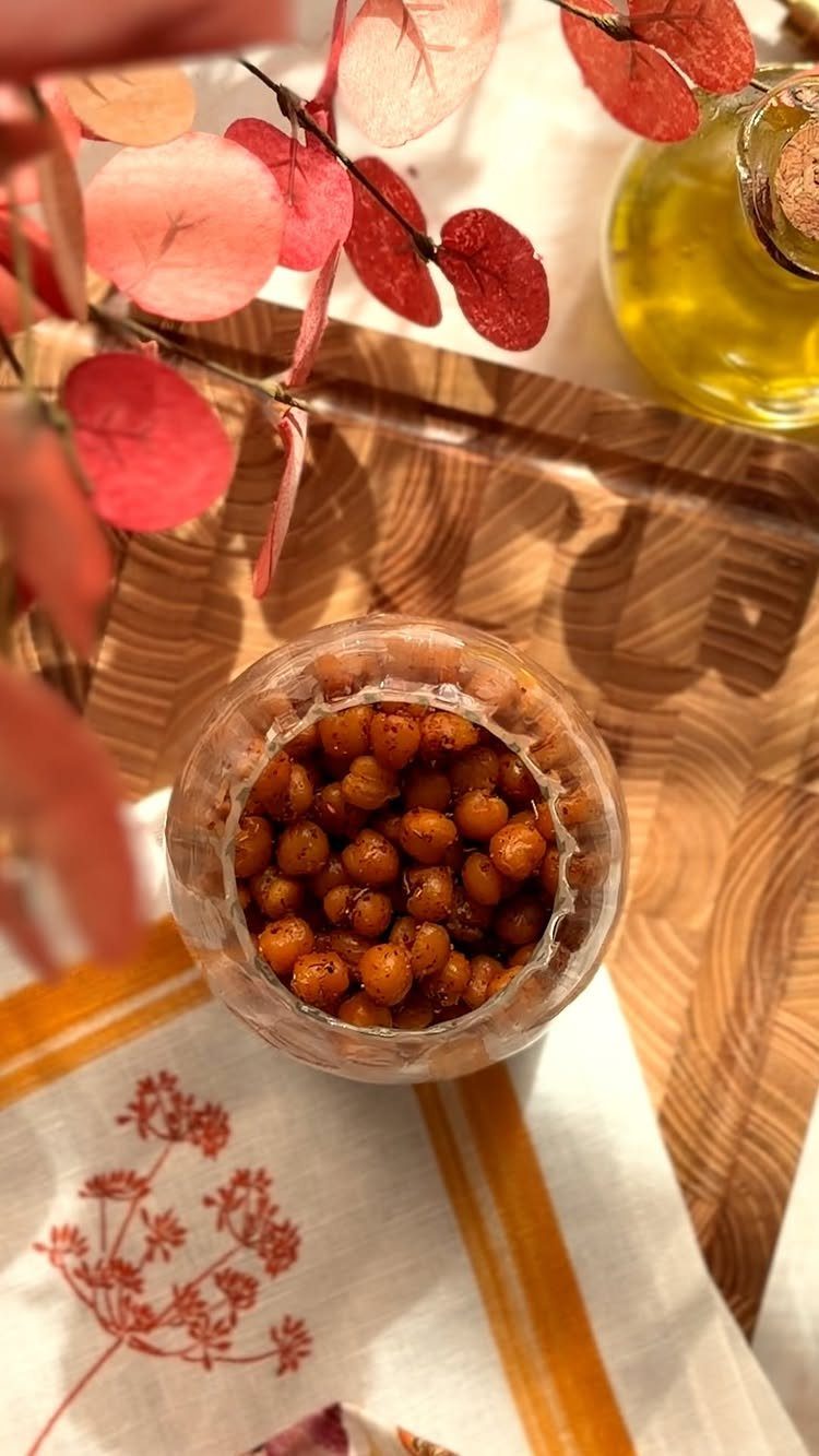 21 Healthy Mini Snacks for Lunchboxes, Parties and Busy Days 14 Roasted golden-brown chickpeas in a glass jar on a wooden tray.