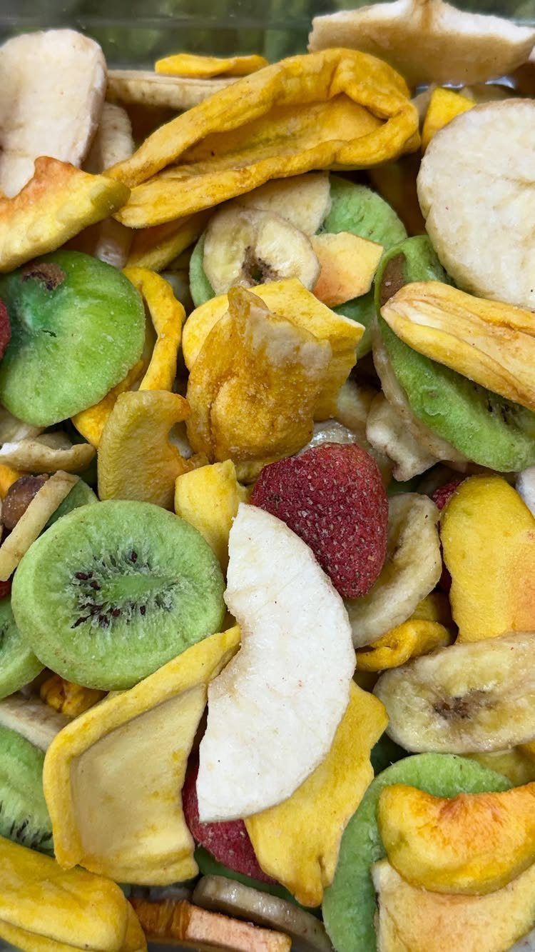 Assorted dried fruit slices including kiwi, mango, apple, and strawberry in a pile.