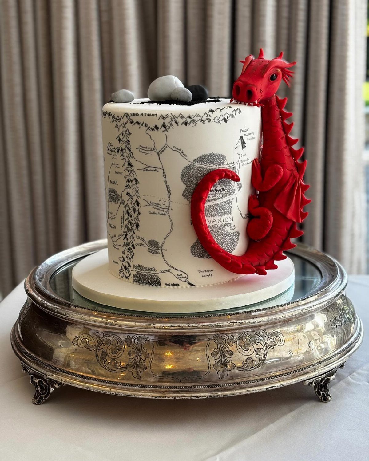 White map cake with a red sculpted dragon on a silver platter