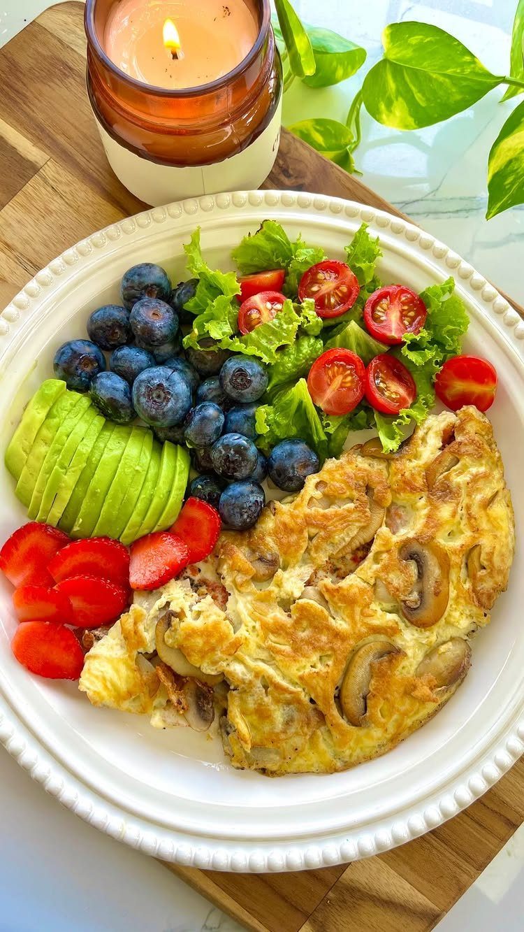16 Morning Healthy Breakfast Ideas, From Egg Bites to Oats 3 Mushroom omelet served with sliced avocado, fresh berries, and a small side salad.