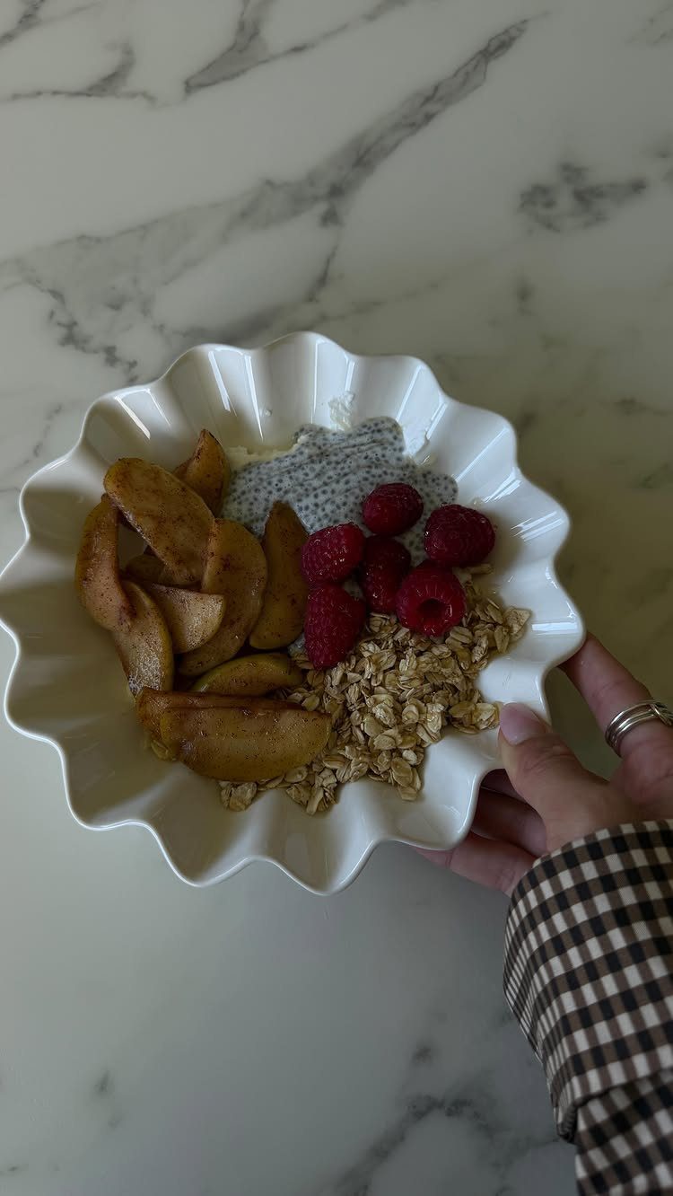 16 Morning Healthy Breakfast Ideas, From Egg Bites to Oats 5 Yogurt bowl with raspberries, sautéed apples, oats, and chia seeds on marble surface.