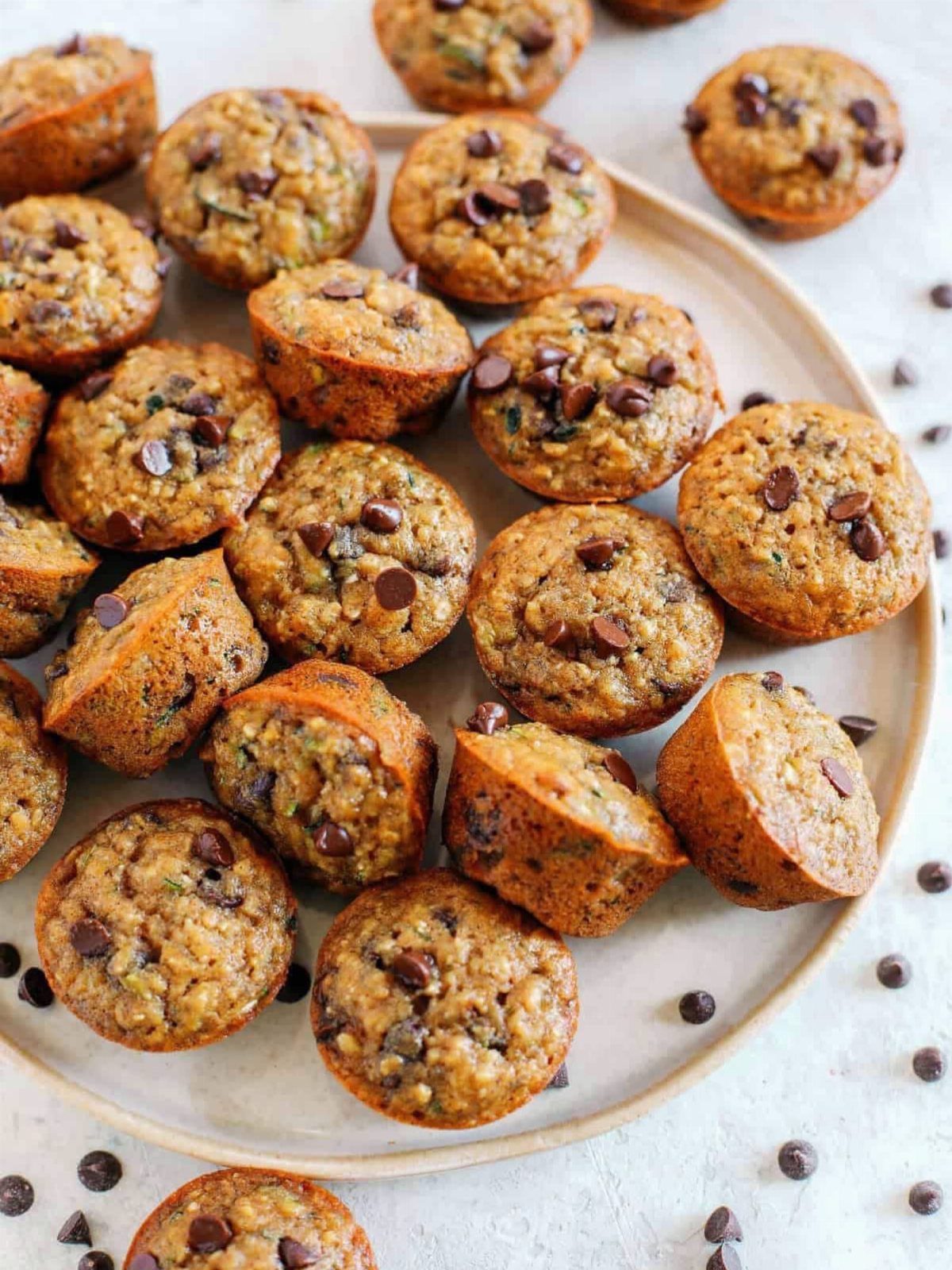 26 Oats Recipes for Snacks, from Energy Bites to Oat Crackers 5 Baked oatmeal cups with chocolate chips arranged on a white ceramic plate.
