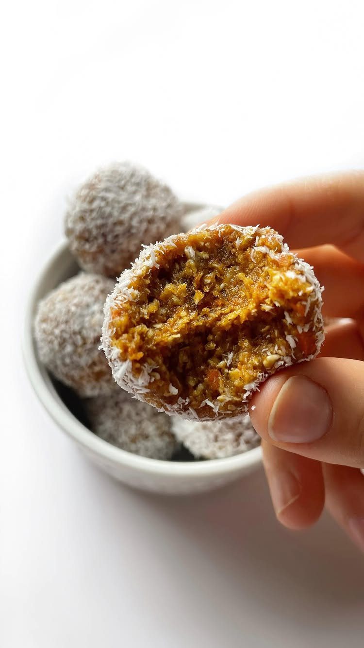 26 Oats Recipes for Snacks, from Energy Bites to Oat Crackers 10 Oatmeal carrot bites coated in coconut, one held and bitten in a hand.