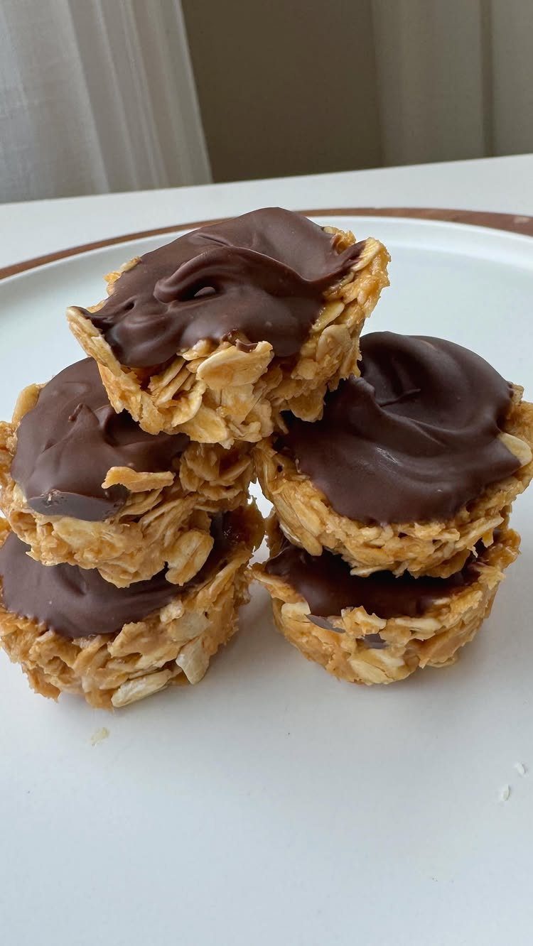 26 Oats Recipes for Snacks, from Energy Bites to Oat Crackers 17 Oatmeal cups topped with melted dark chocolate stacked on a white plate.