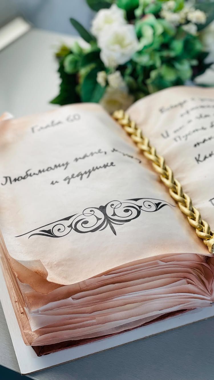 13 Open Book Cakes, from Fairytale Pages to Library Shelves 12 Open book cake with aged pages, handwritten text, and a gold braided spine.