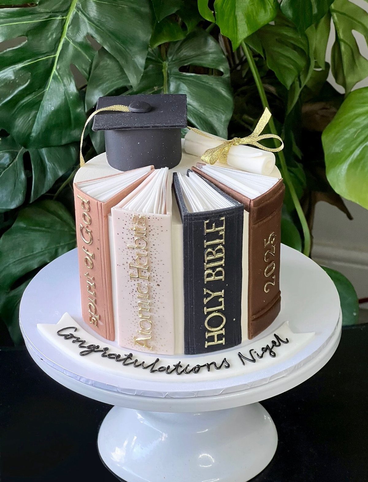 13 Open Book Cakes, from Fairytale Pages to Library Shelves 7 Graduation cake shaped like a stack of books with a mortarboard and diploma topper.