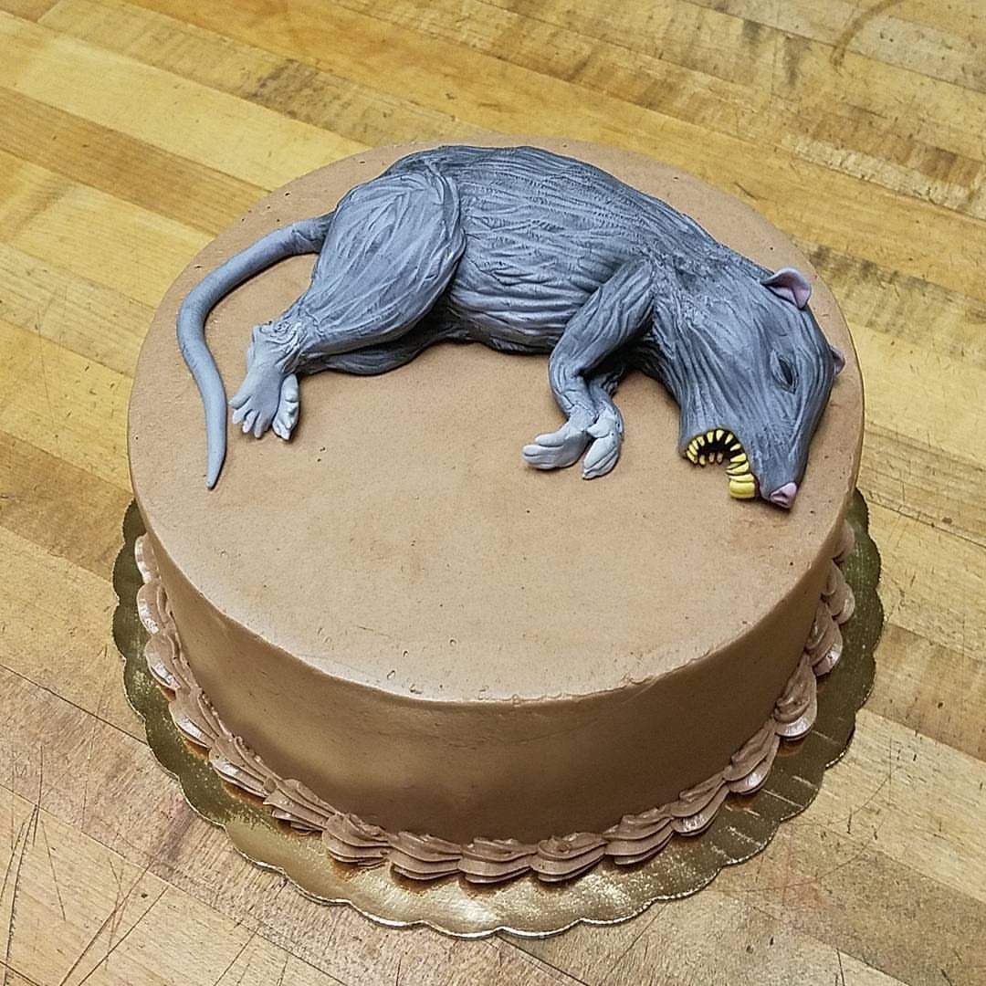 Rat Birthday Cake: 12 Ideas for Pet Rats, Pirates and Chefs 4 Brown frosted cake topped with a realistic grey sculpted rat figure on wooden table.