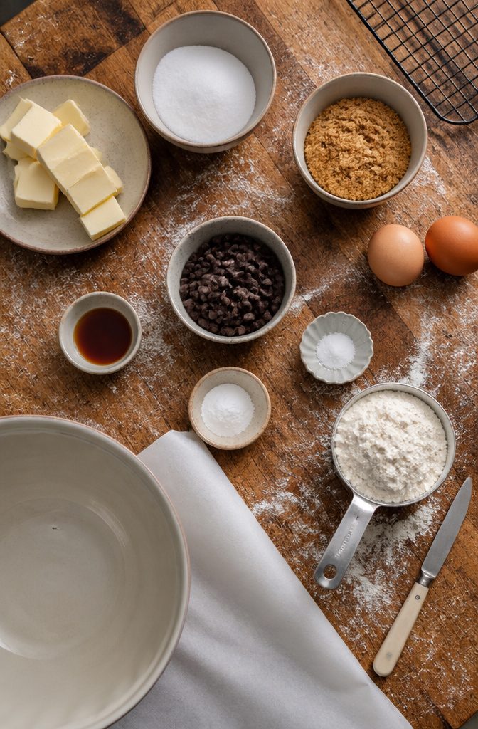 Butter eggs sugars flour and chocolate chips arranged for cookie dough