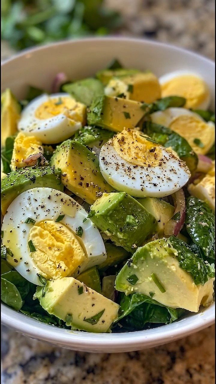 32 Ideas on What to Serve for Breakfast, From Eggs to Scones 20 Breakfast salad with hard-boiled eggs, avocado, and spinach in a white bowl.