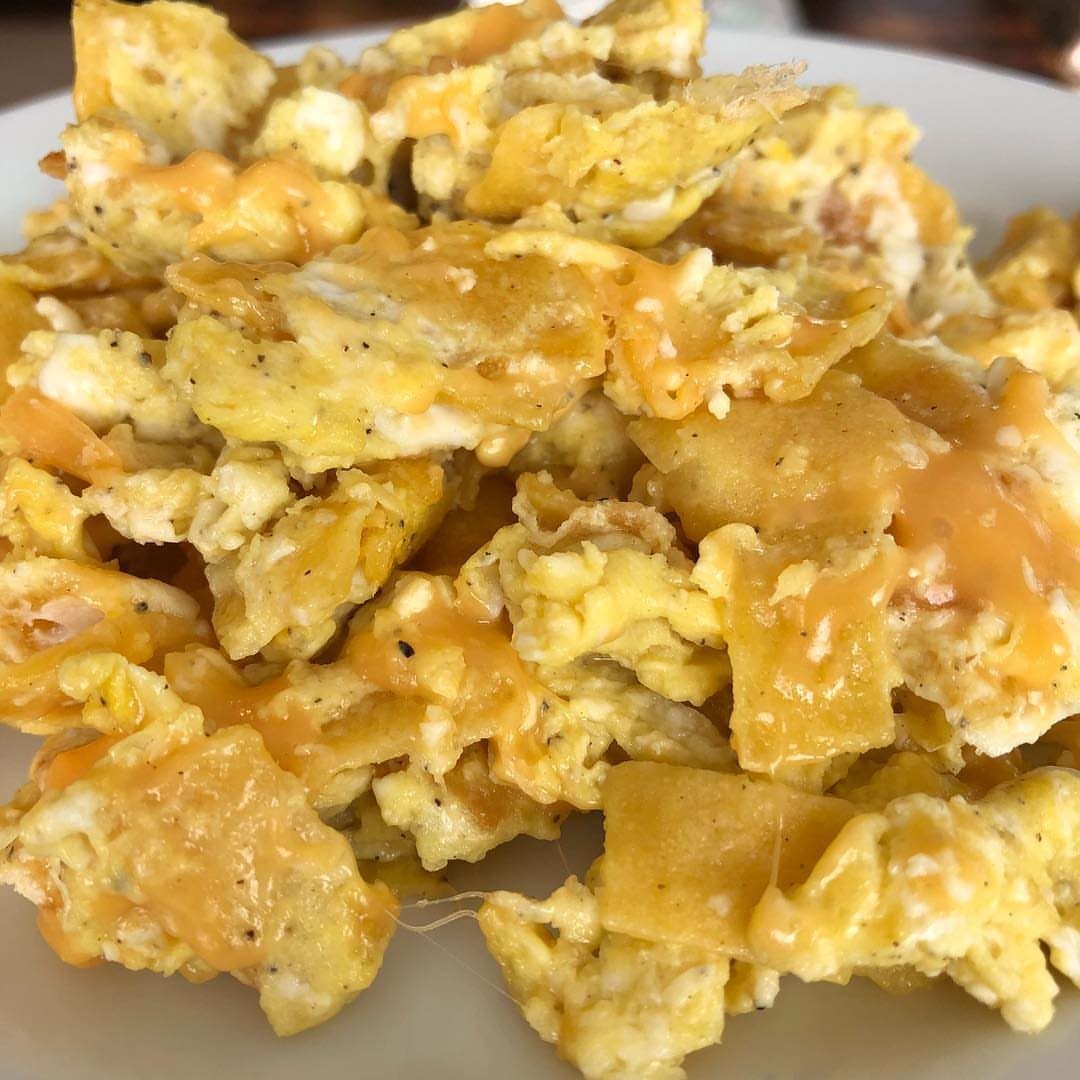 32 Ideas on What to Serve for Breakfast, From Eggs to Scones 30 Migas consisting of scrambled eggs, crispy tortilla pieces, and melted cheese on a plate.