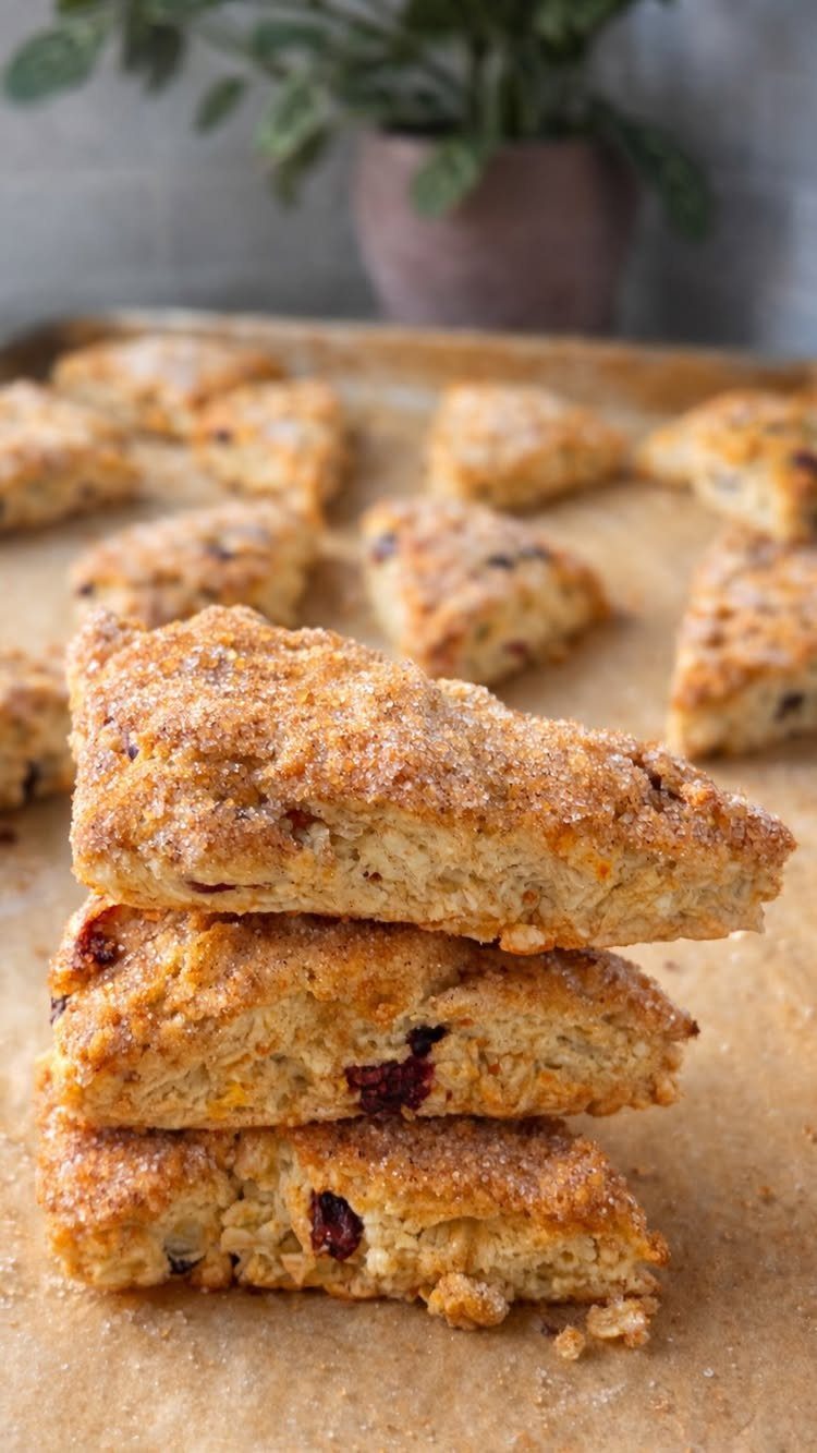 32 Ideas on What to Serve for Breakfast, From Eggs to Scones 33 Stacked triangular berry scones with sugar crust on a parchment-lined baking sheet.